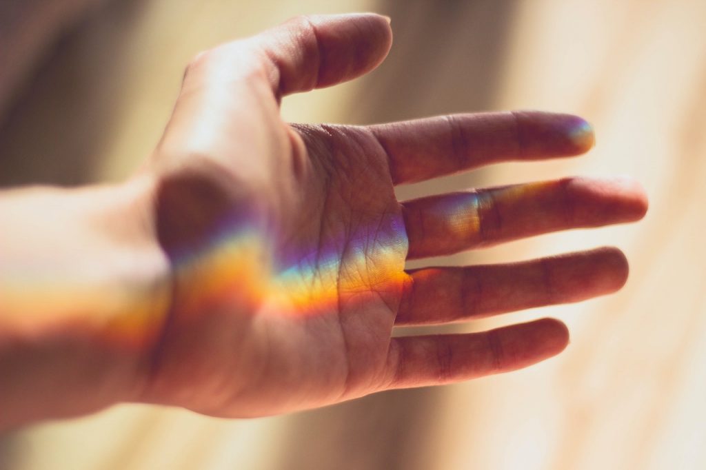 male hand showing the reflction of light in rainbow colors