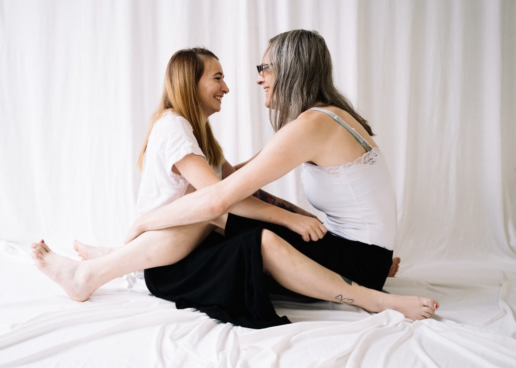 two women sitting opposite each other and smiling at each other