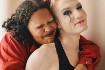 Two women happily embracing from behind.