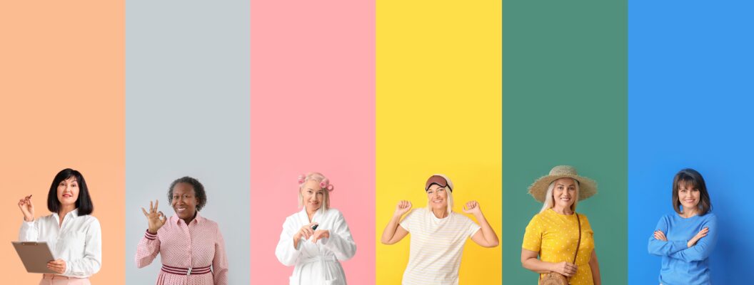 Verschiedene Frauen mittleren Alters stehen vor bunten, pastellfarbenen Hintergründen nebeneinander. Alle lachen und haben verschiedene Outfits an. Die Farben sehen nebeneinander in etwa wie ein Regenbogen aus.